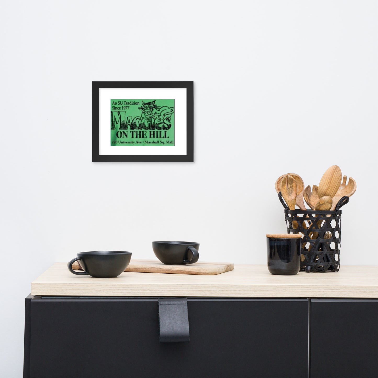 Black framed college bar logo in green that says 'Maggie's on the Hill'